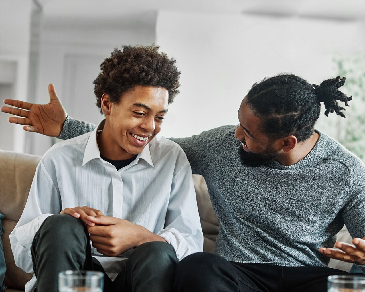 Father and teen son talk laughing